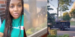 Woman in green Champion shirt, armed SWAT officer behind tree, and SWAT vehicle on residential street