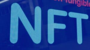 Close-up of the word "NFT" in large blue letters on a digital screen.