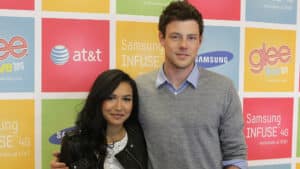 Naya Rivera and Cory Monteith posing at the Glee Live Tour 2011 event with Samsung and AT&T branding background.