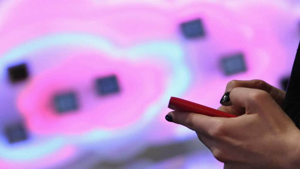 HANOVER, GERMANY - MARCH 05: A visitor tries out a Microsoft-driven Nokia smartphone next to a symbol of a cloud at the Deutsche Telekom stand the day before the CeBIT 2012 technology trade fair officially opens to the public on March 5, 2012 in Hanover, Germany. CeBIT 2012, the world's largest information technology trade fair, will run from March 6-10, and advances in cloud computing are a major feature this year.