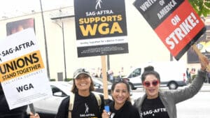 BURBANK, CALIFORNIA - MAY 24: Sarah Haruko, Narmar Hanna and Saye Yabandeh participate in the Writers Guild Of America Strike: Superhero Day held in front of Warner Bros. Studios on May 24, 2023 in Burbank, California.