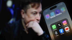 ANKARA, TURKIYE - JULY 30: In this photo illustration, the logos of various social media apps including 'X' (formerly known as Twitter) are displayed on a phone screen in front of a screen displaying the picture of Elon Musk in Ankara, Turkiye on July 30, 2023.