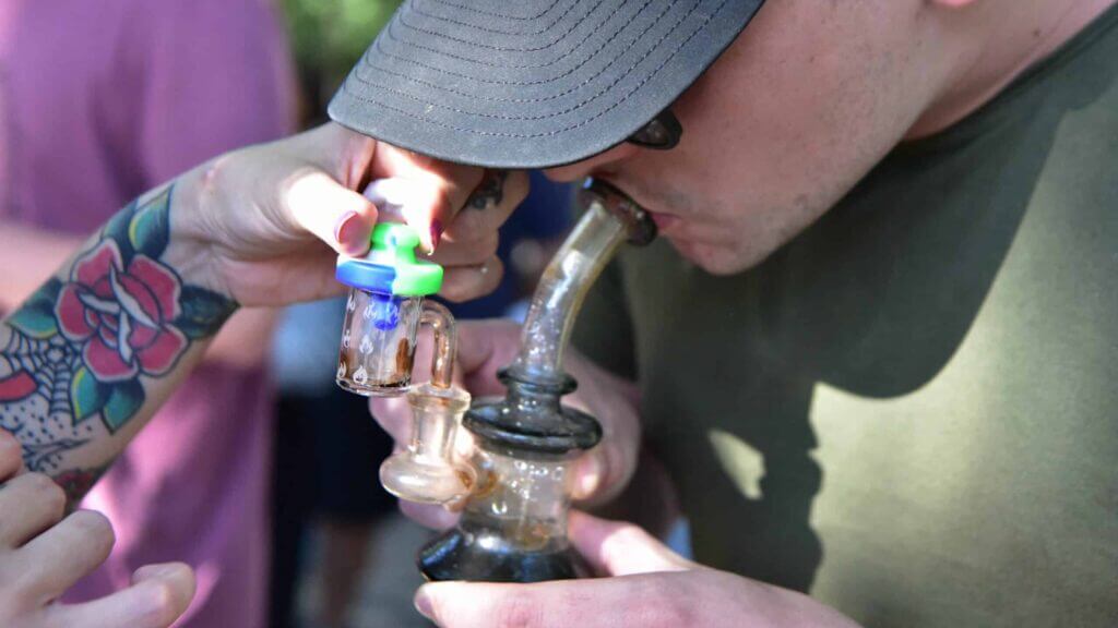 A man smokes marijuana resin during the founding of Paraguay's first cannabis club in Asuncion on June 4, 2023. The non-profit civil association seeks to directly link peasant producers with users of all kinds, guaranteeing the safety and quality of products made from organic flowers from cannabis crops. (Photo by NORBERTO DUARTE / AFP)