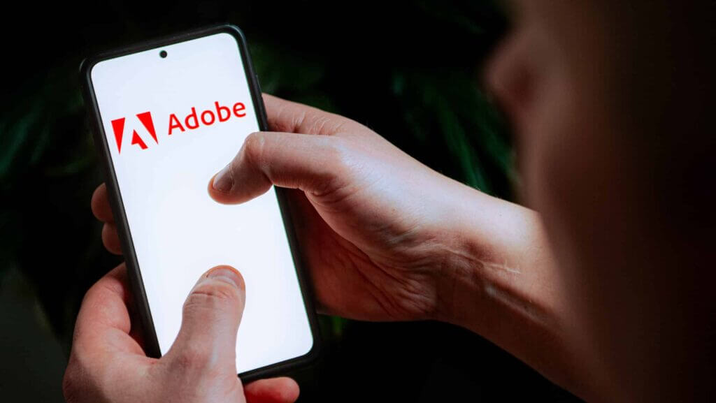 In this photo illustration an Adobe logo seen displayed on a smartphone.