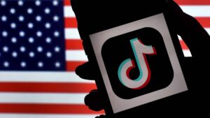 TikTok is displayed on the screen of an iPhone on an American flag background on August 3, 2020 in Arlington, Virginia. - The US Senate voted on August 6, 2020, to bar TikTok from being downloaded onto US government employees' telephones, intensifying US scrutiny of the popular Chinese-owned video app. The bill passed by the Republican controlled Senate now goes to the House of Representatives, led by Democrats.