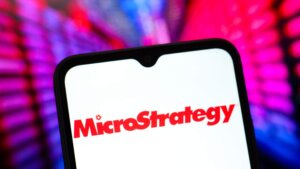 MicroStrategy logo displayed on a smartphone screen with colorful blurred background