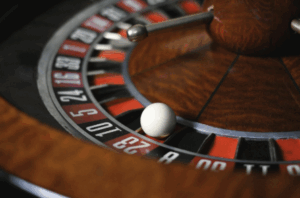 Roulette wheel with ball landing on number 23 red slot.