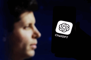 Person holding a smartphone displaying the ChatGPT app logo against a dark background.